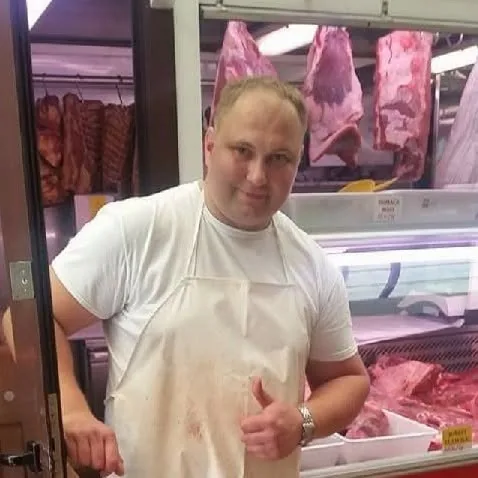 Tomo Hačić u pregači ispred pulta s mesom